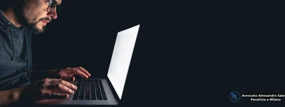 Truffatore informatico al PC al buio mentre commette il reato di truffa online minorata difesa, tematica giuridica trattata dall'Avvocato penalista Milano.