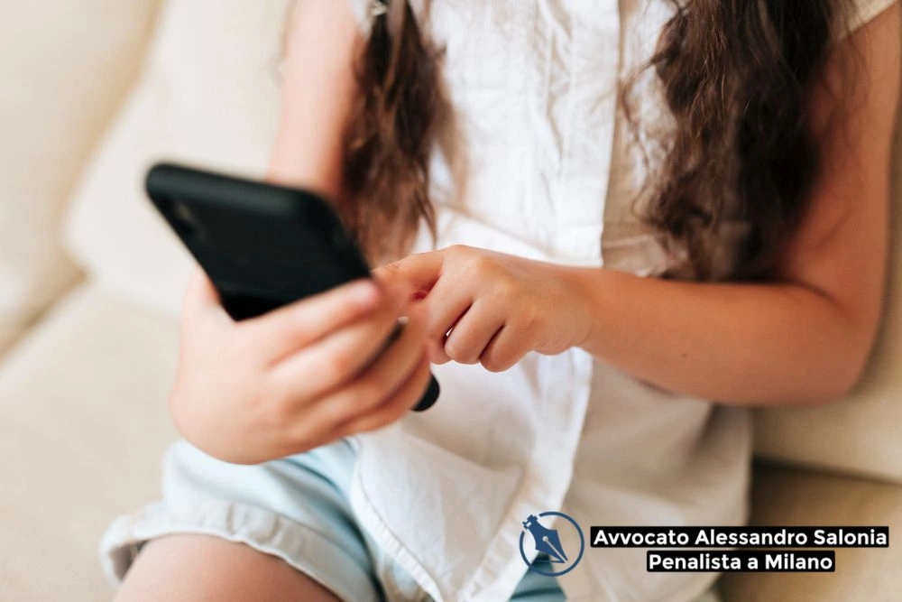 Minore con smartphone in mano, immagine simbolica relativa ai reati di atti sessuali online con minorenne e all'importanza dell'assistenza di un avvocato penale Milano.