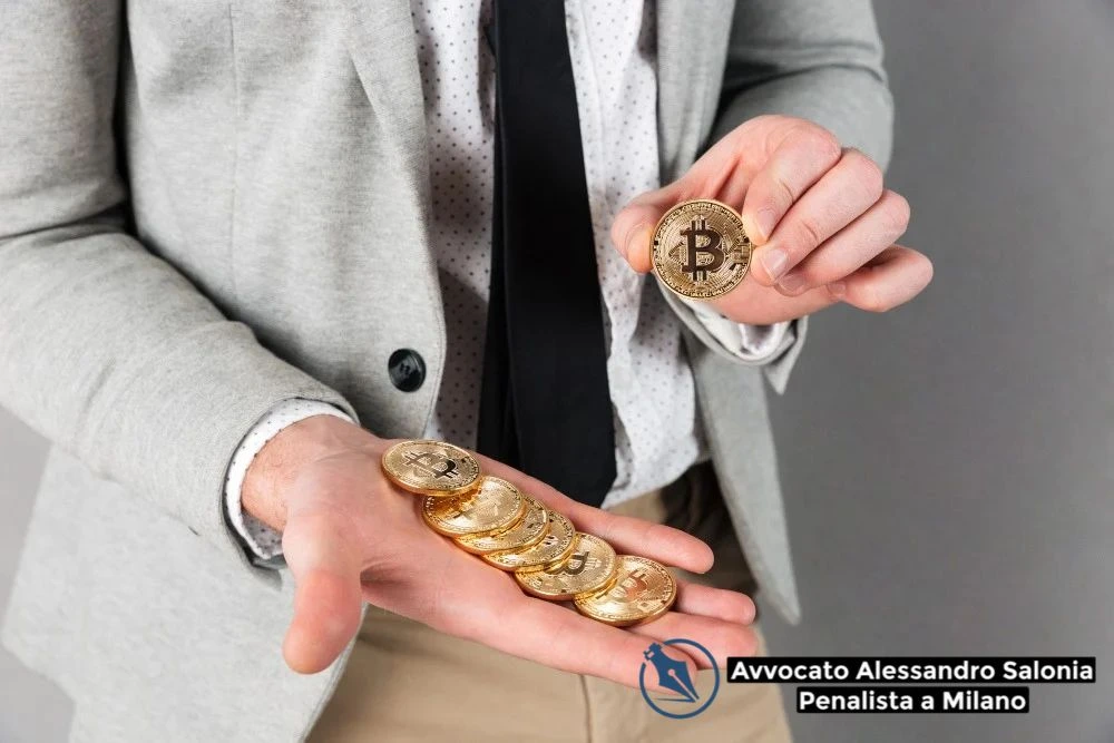Autoriciclaggio e Criptovalute Avvocato Penale Milano: professionista in giacca e cravatta mostra monete Bitcoin con logo Avvocato Alessandro Salonia.
